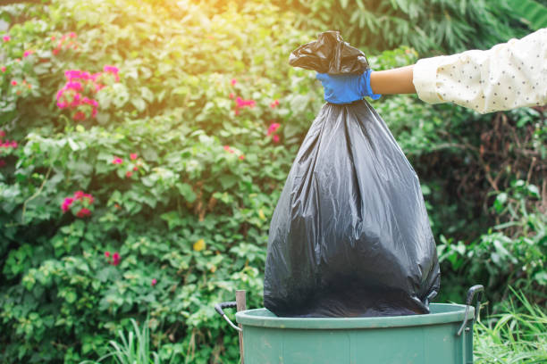 istock Human hand holding plastic bag in to trash 1062390730