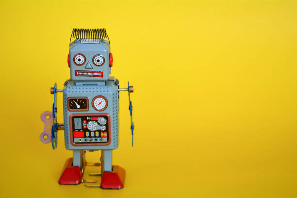 istock Vintage tin toy robot isolated on a yellow background. 1062392514