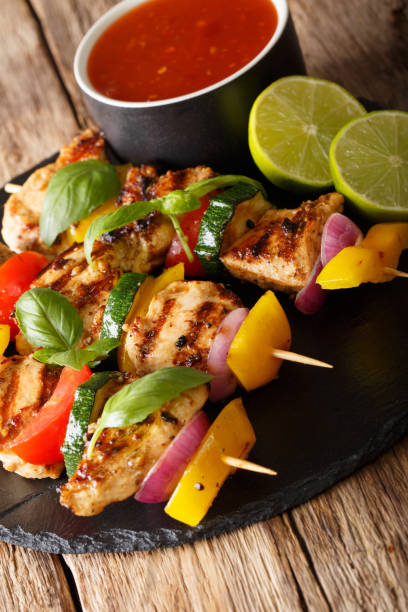 istock spicy grilled chicken kebabs with vegetables served with ketchup close-up. vertical 1062402010