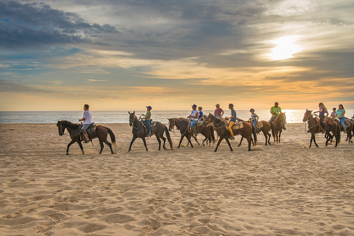 Summertime in PUNTA LOBOS Beach, local people riding horses, Todos Santos, Baja California Sur. MEXICO