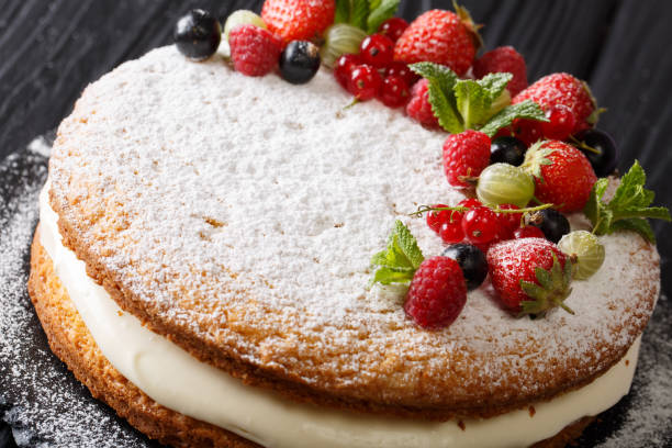istock Beautiful dessert: Victoria sandwich cake decorated with fresh summer berries and mint closeup. horizontal 1062410064
