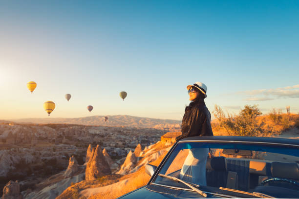 Beautiful asian woman watching colorful hot air balloons flying over the valley at Cappadocia,  Turkey Cappadocia fairytale scenery of mountains. Only Women, Woman, Turkey - Middle East, Young Adult, 30-39 Years, Hot Air Balloon turkey middle east stock pictures, royalty-free photos & images