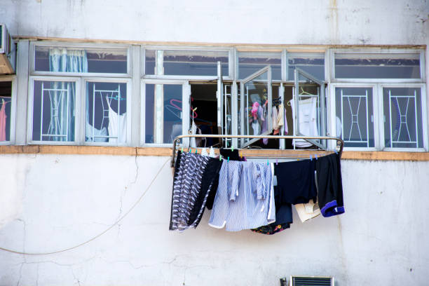 образ жизни гонконгцы висят сухую одежду на солнце на открытом воздухе окна высокой квартиры здания - kennedy center стоковые фото и изображения