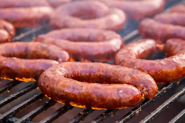 Close up view of many portuguese chorizos on a barbecue.