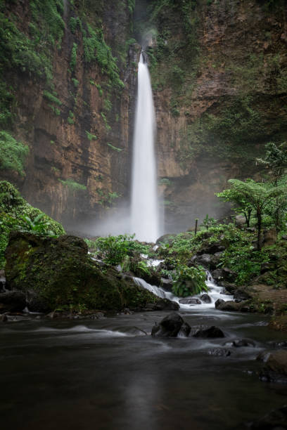istock Dramatic long exposure of Kapas Biru waterfall in Indonesia 1062430212