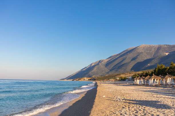 istock Sunrise over an empty beach with umbrellas 1062431150