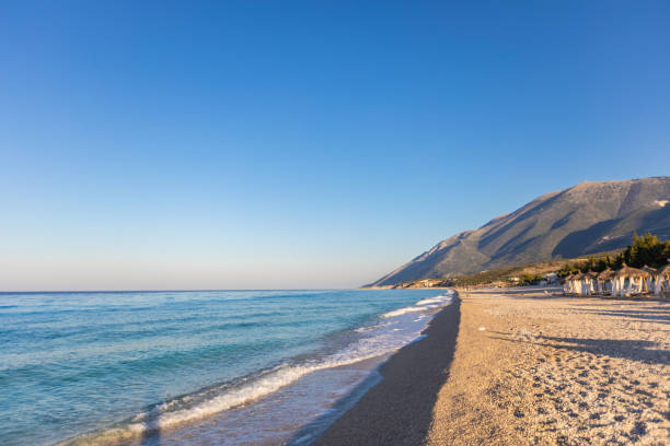 istock Sunrise over an empty beach with umbrellas 1062431156