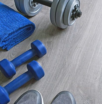 Sport fitness objects on light grey wooden background. Active lifestyle, weight loss, body care concept. Empty text space. Top view.