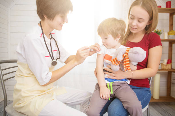 A doctor giving a child an injection at home A doctor giving a child an injection at home. diabetes epidemiology stock pictures, royalty-free photos & images