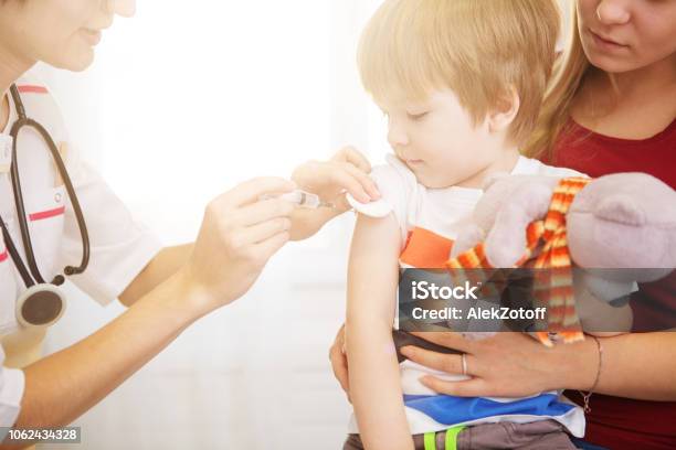 A Doctor Giving A Child An Injection At Home Stock Photo - Download Image Now - Vaccination, Child, Baby - Human Age