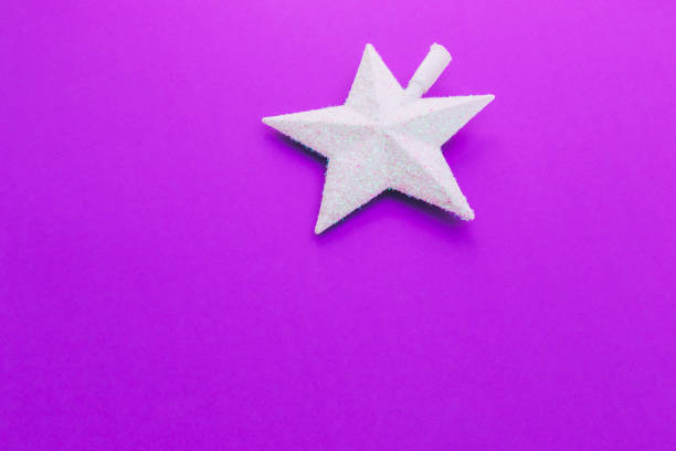 istock Creative Christmas shiny white star on purple background. 1062436612