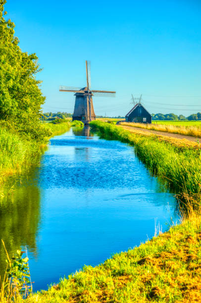 istock Dutch landscape with vintage windmill at sunset (HDRi) 1062439530
