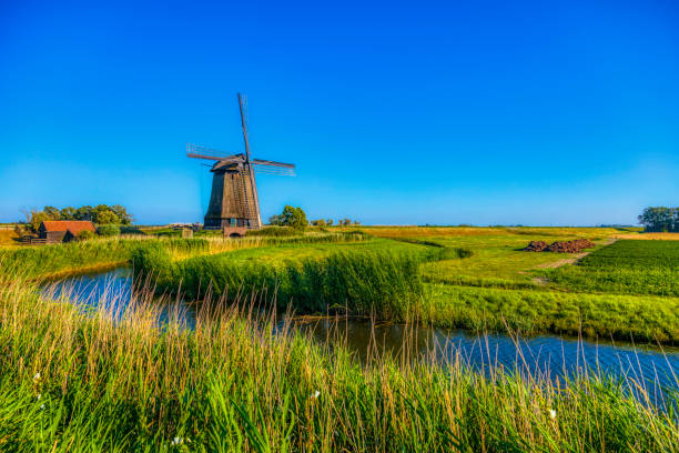 istock Dutch landscape with vintage windmill at sunset (HDRi) 1062439546