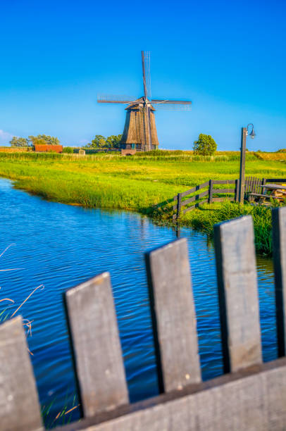 istock Dutch landscape with vintage windmill at sunset (HDRi) 1062439548