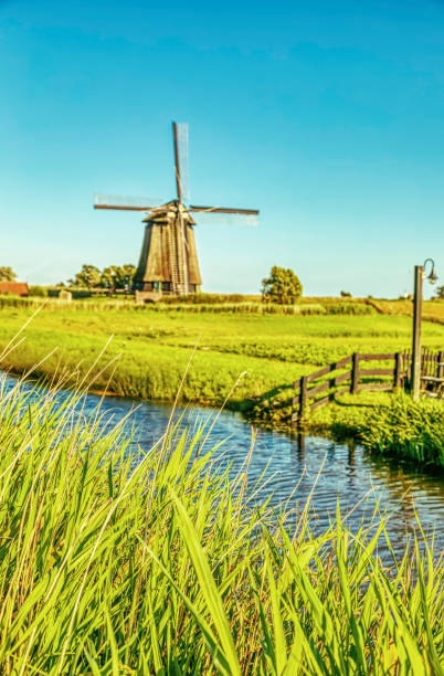 istock Dutch landscape with vintage windmill at sunset (HDRi) 1062439564