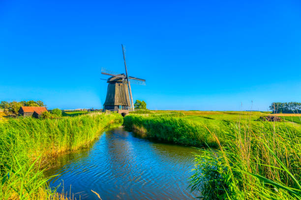istock Dutch landscape with vintage windmill at sunset (HDRi) 1062439580