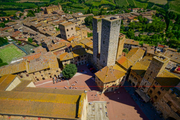 vista aérea da torre medieval e telhados de san gimignano, uma cidade de colina e sua praça com turistas, itália - italy panoramic town square skyline - fotografias e filmes do acervo