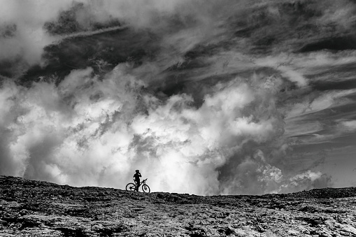Cyclist silhouette and gorgeous cloudscape on Cima Rosetta - Trentino Alto Adige, Italy