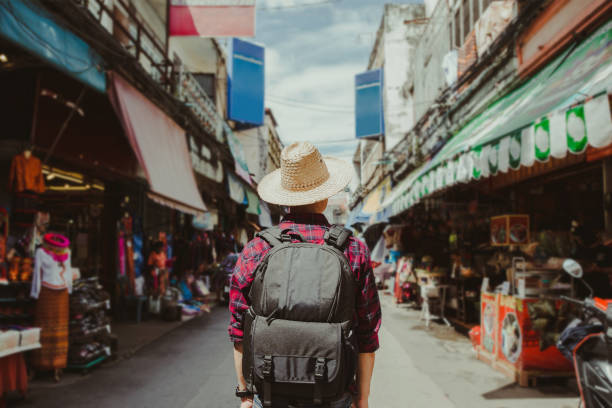 istock Young man traveling backpacker with hat  walking in walking street. 1062445868