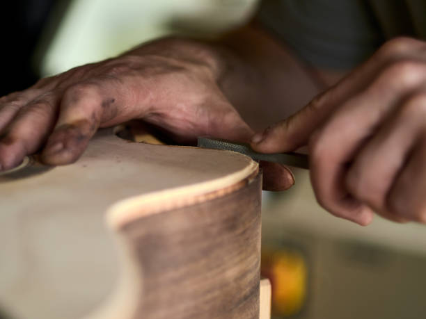 istock Luthier Install Binding on an guitar. Chamfering on the body of the guitar. 1062446740