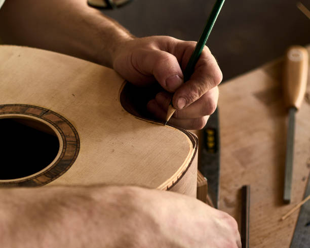 istock Luthier Install Binding on an guitar. Chamfering on the body of the guitar. 1062446802