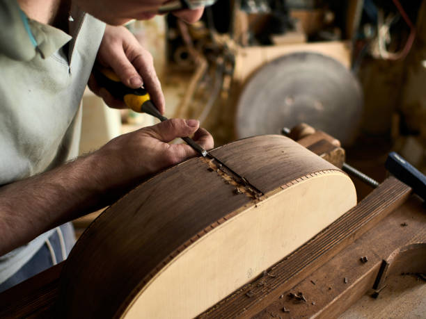 istock Luthier Install Binding on an guitar. Chamfering on the body of the guitar. 1062446874