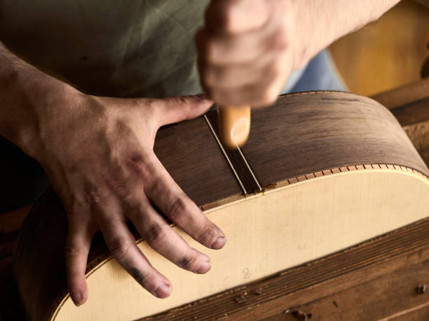 istock Luthier Install Binding on an guitar. Chamfering on the body of the guitar. 1062446876