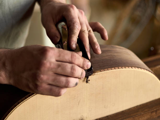 istock Luthier Install Binding on an guitar. Chamfering on the body of the guitar. 1062446880