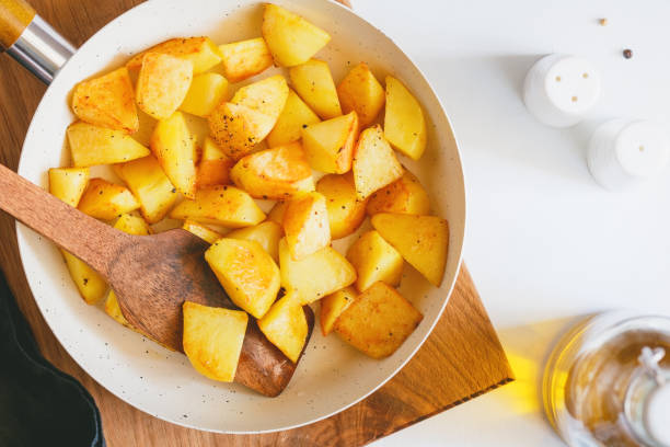 istock Top view on roasted potato in a white pan on a kitchen table. Modern style, vegetarian food. 1062453276