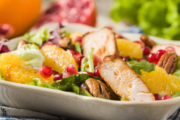 istock Spring salad with chicken, pomegranate, orange, pecan nuts and honey. 1062456880