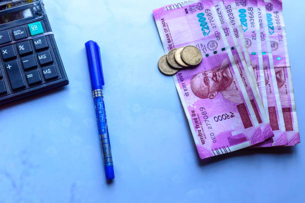 Indian paper currency rupees and coins stack, calculator and pen
