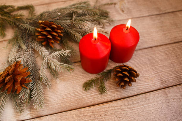 istock two burning red candles with fir branches 1062463344