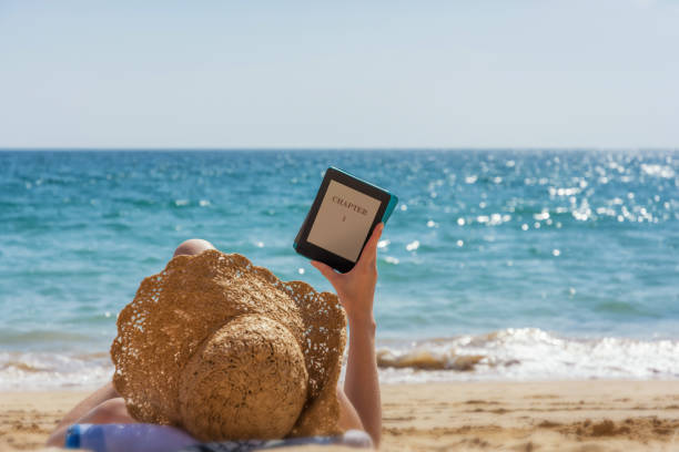 istock Woman relaxes while reading on the beach 1062471796