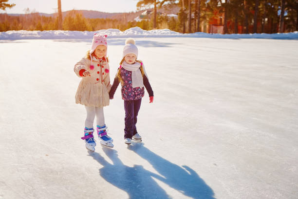 istock Two little girls hold hands and skate. Space for text 1062471798