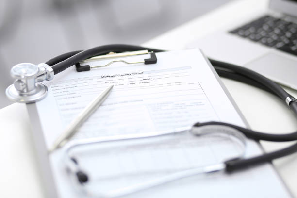 istock Stethoscope, clipboard with medical form lying on hospital reception desk with laptop computer. Medical tools at doctor working table. Medicine and health care concept 1062473028