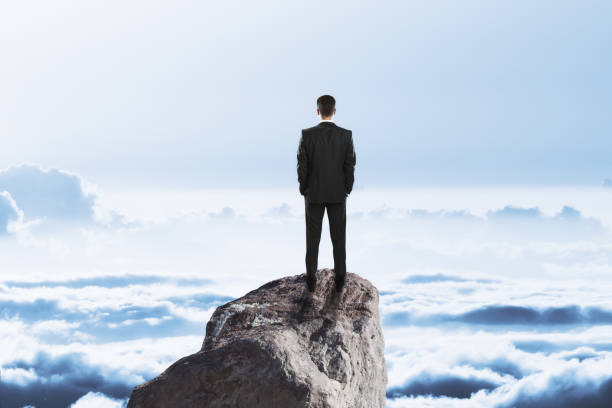 istock businessman on rock above clouds 1062474286