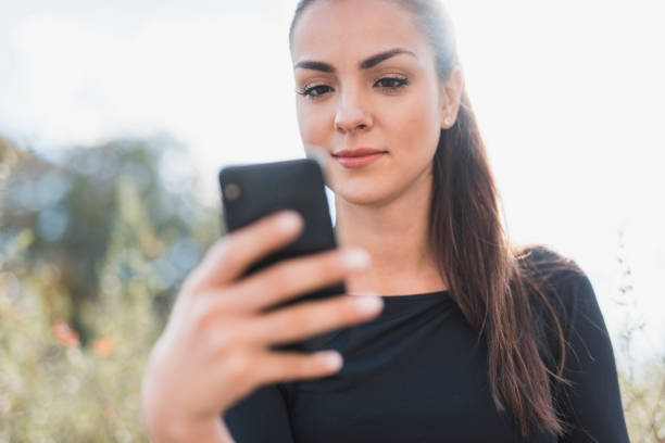 istock Low angle view of a woman using a smart phone outdoors 1062479862