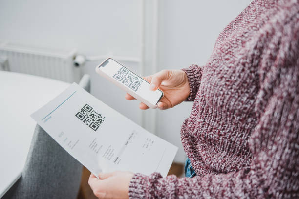 istock Woman scanning the qr code on a bill with a smart phone on the kitchen counter 1062480756