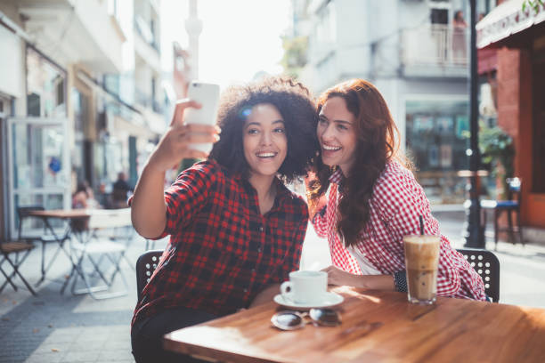 istock Best friends drinking coffee and taking photos 1062484684