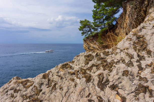 istock White boat and rocky cliff on turquoise sea 1062487010