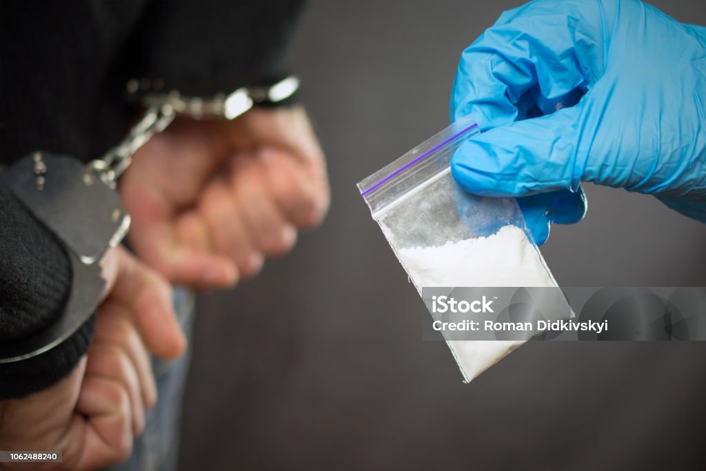 police detention drug courier. A police officer finds drugs during the search of drug dealers Recreational Drug Stock Photo
