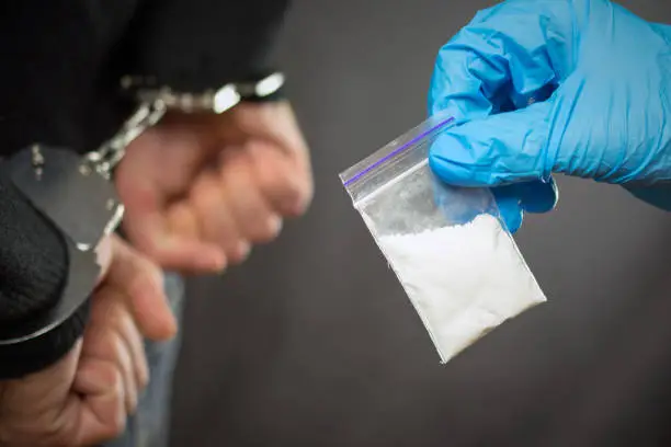 A police officer finds drugs during the search of drug dealers
