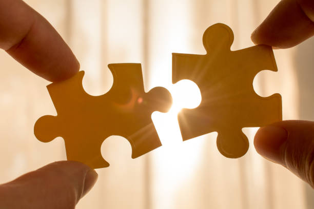 istock couple puzzle piece with sunset background. 1062489612