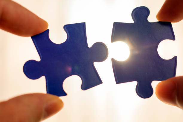 istock two hands trying to connect couple puzzle piece. 1062490278