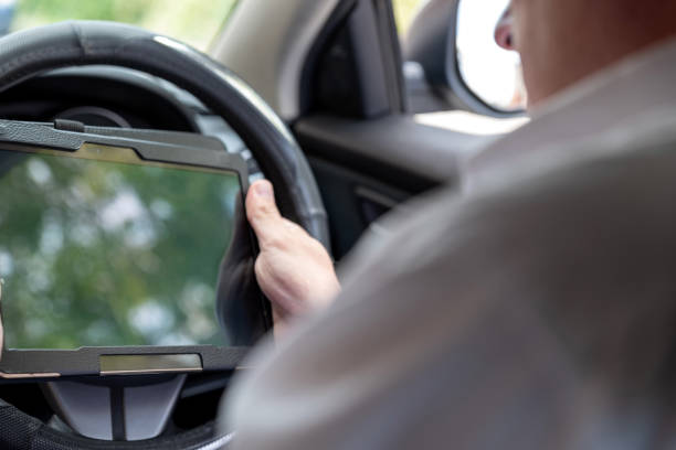 istock Businessman working on tablet and smartphone inside car on bright day 1062490640