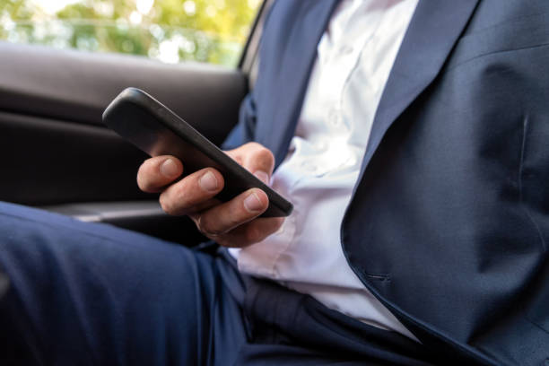 istock Businessman working on tablet and smartphone inside car on bright day 1062490788