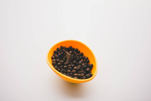 Dry ginger, Black pepper, Large cardamom in a bowl and in a plate with white background