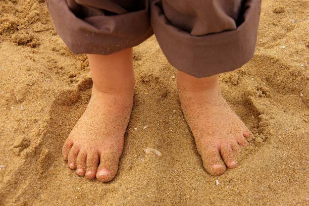 istock Child feet in the sand 1062492576