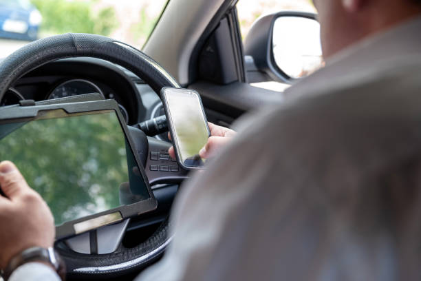 istock Businessman working on tablet and smartphone inside car on bright day 1062495506