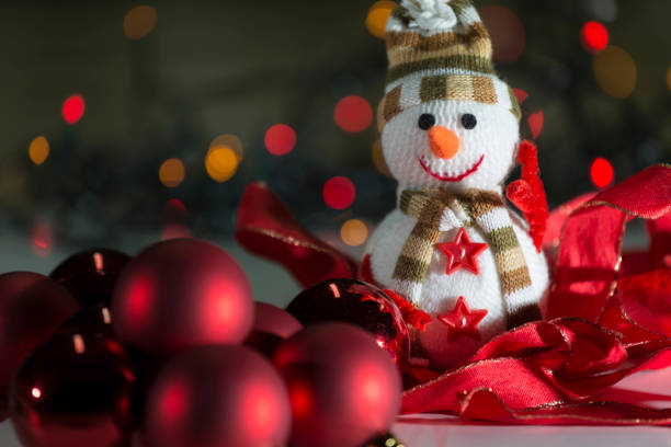 colored lights and red ribbons surrounding the representation of a snowman made with wool. Christmas, ornaments and longings